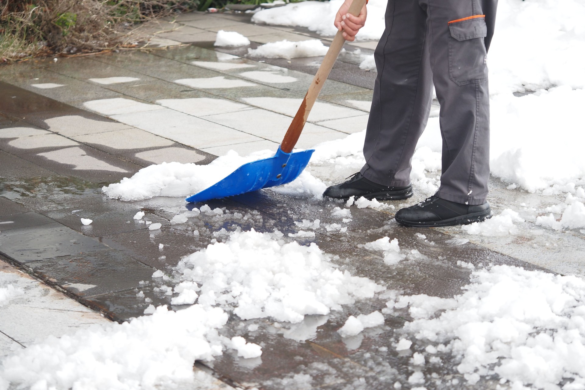 Shoveling snow from a walkway during winter cleanup